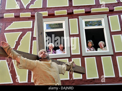 Residents watch while a crucifixion is acted out by about 100 actors in Bensheim, Hesse, 22 April 2011. Thousands of spectators watched the live illustration of the christian crucifixion on Easter's Good Friday, which was reenacted at different locations of the medieval town. Photo: Boris Roessler Stock Photo