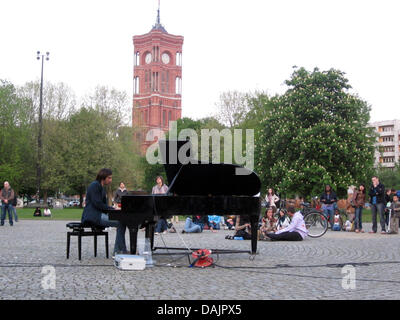 Pianist Davide Martello plays on a grand piano at the Marx Engels Forum square in Berlin, Germany, 25 April 2011. He is influenced by neoclassical composers like George Winston or Arturo Stalteri. His repertoire currently holds 90 compositions by himself. Photo: XAMAX Stock Photo