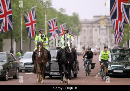 Mounted police officer patrol passes down a street surrounded by Union Jack flags in front of the Buckingham Palace in London, Great Britain, 28 April 2011. London is preparing for the royal wedding between Britain's Prince William and Kate Middleton at Westminster Abbey on 29 April 2011. Photo: Kay Nietfeld