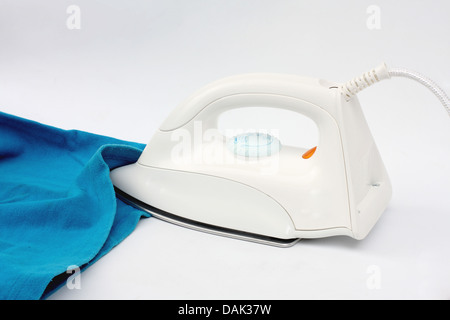 Pile of colorful clothes and electric iron on white background Stock Photo