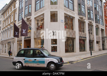 Taxi going past Louis Vuitton shop New Bond Street Mayfair district central London England Britain UK Europe