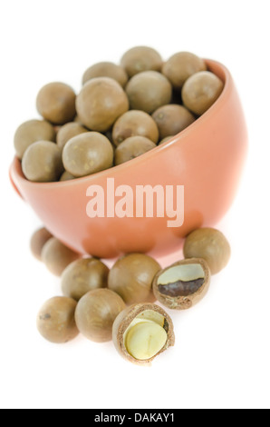 Shelled and unshelled macadamia nuts in a cup on white Stock Photo