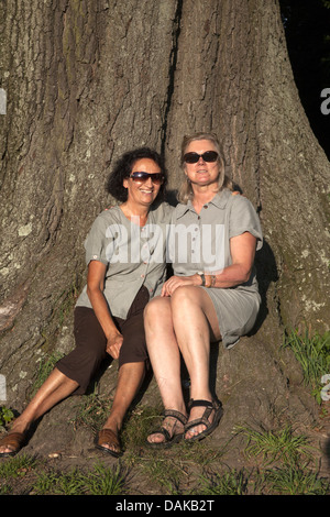 Two sixty something year old friends pose together for a photo in Prospect Park, Brooklyn, NY. Same age children. Stock Photo