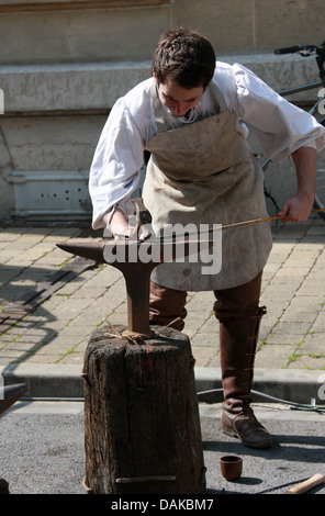 Blacksmith Demonstrating Medieval Method of Iron Working, Joan of Arc Festival, Reims, Marne, Champagne-Ardennes, France. Stock Photo