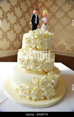 Wedding couple figures on top of a traditional white iced cake. Stock Photo