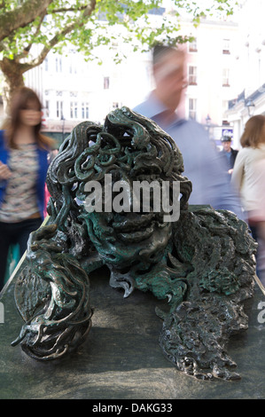 The bronze and granite sculpture “Conversation with Oscar Wilde” made by Maggi Hambling. People are rushing past to Charing Cross Station. London, UK. Stock Photo