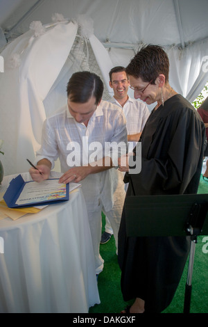 A Deputy Commissioner of Civil Marriages in West Hollywood, CA, officiates at a civil marriage ceremony for a gay male couple. Stock Photo