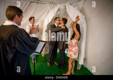 A Deputy Commissioner of Civil Marriages in West Hollywood, CA, officiates at a civil marriage ceremony for a gay male couple. Stock Photo