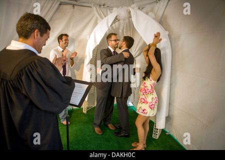 A Deputy Commissioner of Civil Marriages in West Hollywood, CA, officiates at a civil marriage ceremony for a gay male couple. Stock Photo