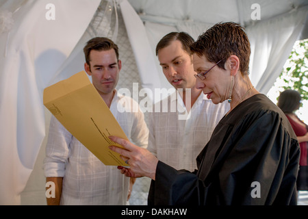 A Deputy Commissioner of Civil Marriages in West Hollywood, CA, officiates at a civil marriage ceremony for a gay male couple. Stock Photo