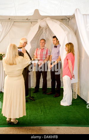 A Deputy Commissioner of Civil Marriages in West Hollywood, CA, officiates at a civil marriage ceremony for a gay male couple. Stock Photo