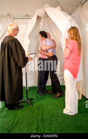 A Deputy Commissioner of Civil Marriages in West Hollywood, CA, officiates at a civil marriage ceremony for a gay male couple. Stock Photo