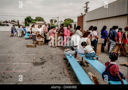 Hungry Hispanic and African American local LA residents line up for free charity food after the 1992 Rodney King race riots. Stock Photo