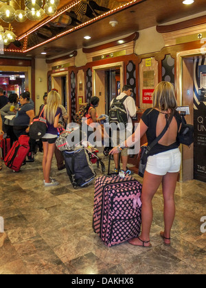 Young customers wait for the elevator with their luggage after checking in a Harrah's Hotel in Las Vegas, NV. Stock Photo