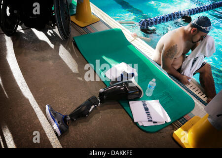 Clearwater, Florida, USA. 15th July, 2013. Jose Miranda, 28, of Pasadena, California, wipes his face after exiting the pool of the Long Center in Clearwater on July 15, 2013 while warming up to swim in the 33rd National Wheelchair Games. Miranda was competing in the 100m freestyle event and says this will be his first time competing at that distance. Miranda was run over by an F-18 fighter aircraft on the dec of an aircraft carrier in October 2004. The accident cost him his right leg. Credit:  ZUMA Press, Inc./Alamy Live News Stock Photo