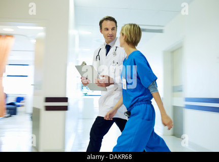 Doctor and nurse walking in hospital hallway Stock Photo