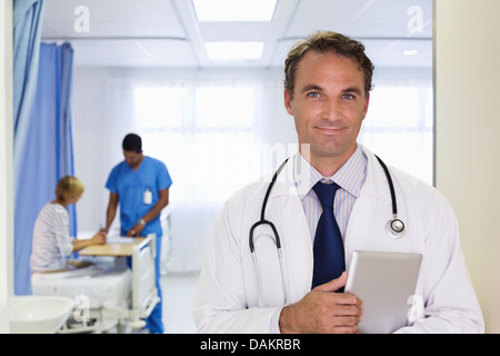 Doctor carrying tablet computer in hospital Stock Photo
