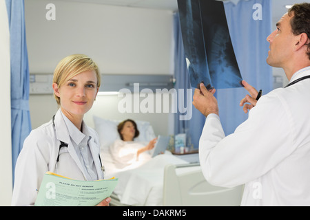 Doctors examining x-rays in hospital room Stock Photo
