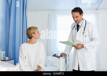 Doctor talking with patient in hospital room Stock Photo