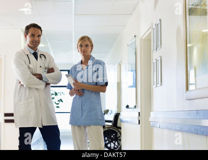 Doctor and nurse standing in hospital hallway Stock Photo