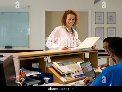 Hospital staff talking at front desk Stock Photo