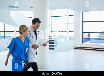 Doctor and nurse talking in hospital hallway Stock Photo