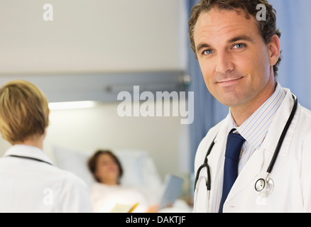 Doctor smiling in hospital room Stock Photo