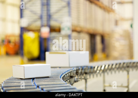 Packages on conveyor belt in warehouse Stock Photo