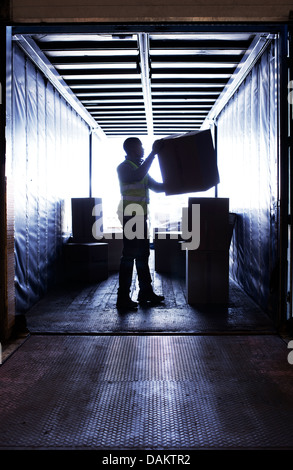 Worker stacking boxes in van Stock Photo