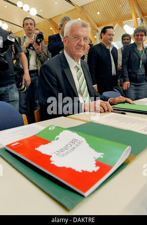 The designated prime minister of the state of Baden-Wuerttemberg, Winfried Kretschmann of the Green Party, sits next to the coalition contract during the extraordinary meeting of the state party fraction at the state parliament in Stuttgart, Germany, 7 May 2011. About six weeks after the vote in Baden-Wuerttemberg, the Social Democrats and the Green Party hold seperate party meetin Stock Photo
