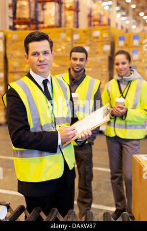 Businessman and workers in warehouse Stock Photo