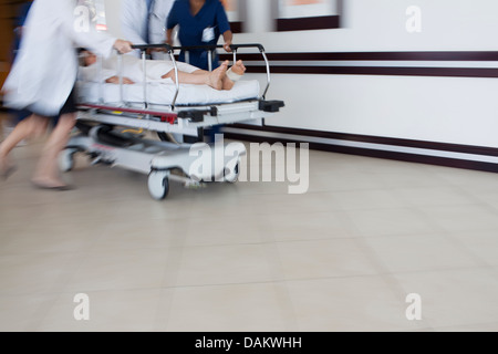 Hospital staff rushing patient to operating room Stock Photo