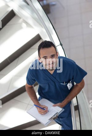 Nurse writing on clipboard on steps Stock Photo