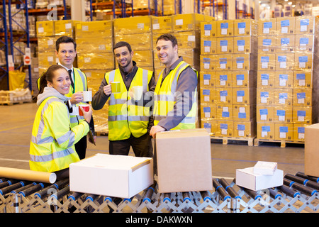 Workers drinking coffee in warehouse Stock Photo