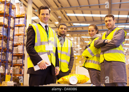 Businessman and workers smiling in warehouse Stock Photo