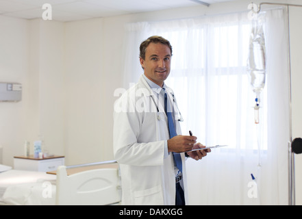 Doctor writing on clipboard in hospital Stock Photo