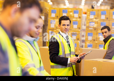 Businessman and workers in warehouse Stock Photo