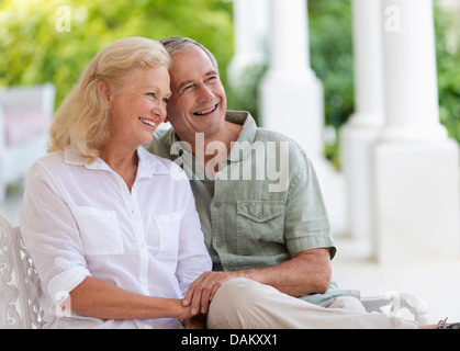 Older couple hugging on porch Stock Photo