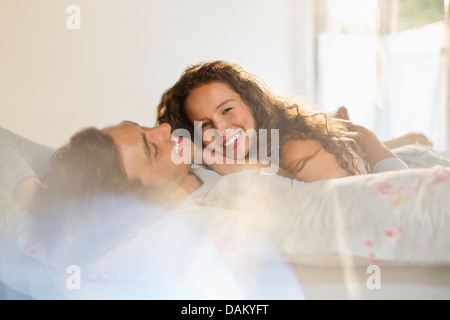 Colour portrait of nude couple in bed holding each other Stock Photo