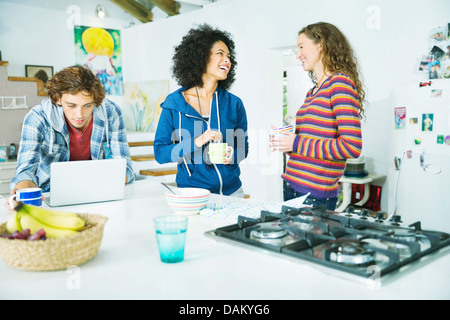 Friends relaxing together in kitchen Stock Photo