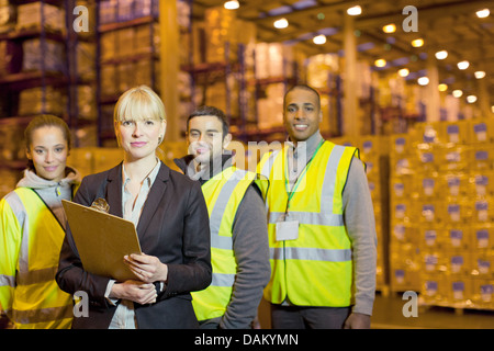 Workers and businesswoman in warehouse Stock Photo
