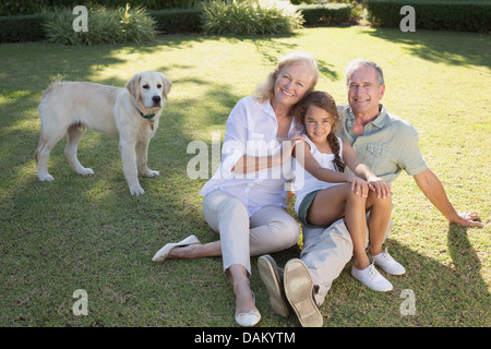Older couple smiling with granddaughter in backyard Stock Photo