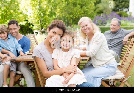 Family smiling at table outdoors Stock Photo