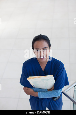 Nurse holding folders in hospital hallway Stock Photo