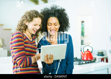 Women listening to earphones together Stock Photo