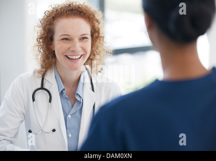 Doctor and nurse talking in hospital hallway Stock Photo