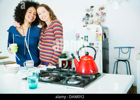 Women hugging in kitchen Stock Photo