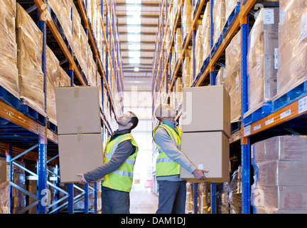 Workers carrying boxes in warehouse Stock Photo