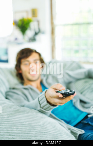 Man watching television in beanbag chair Stock Photo