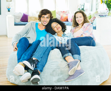 Friends relaxing together in beanbag chair Stock Photo